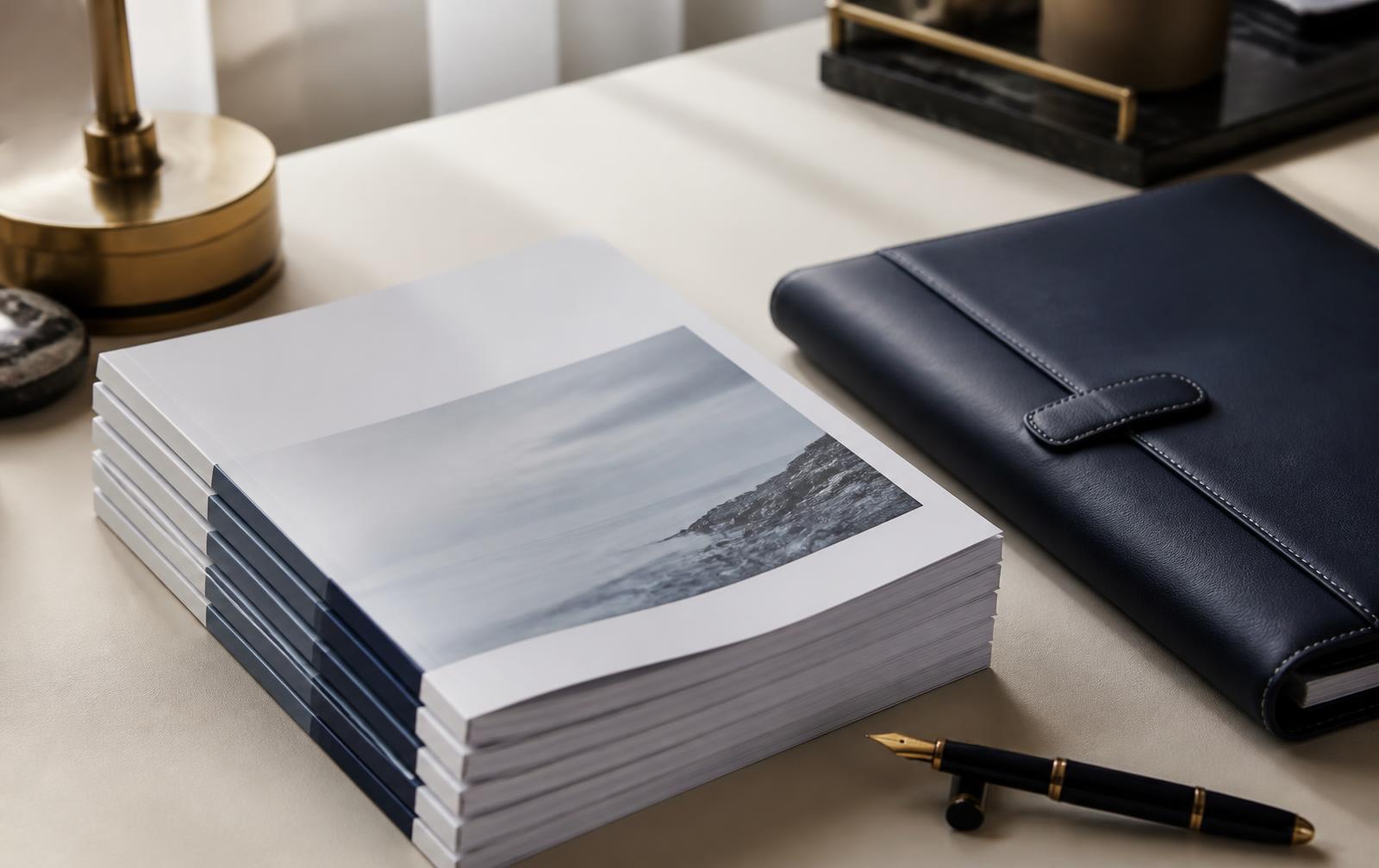 Printed blueprint report pages beside a fountain pen on a dark desk